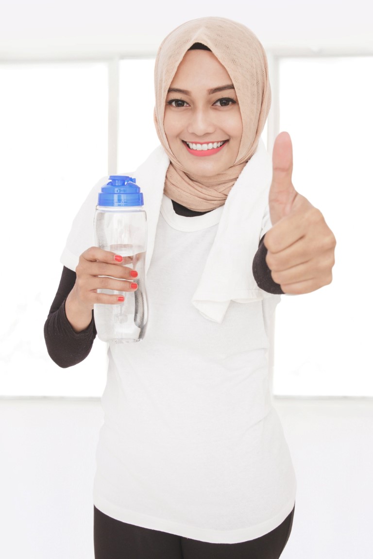 close-up-portrait-muslim-sporty-woman-holding-bottle-mineral-water-giving-thumbs-up (Medium)