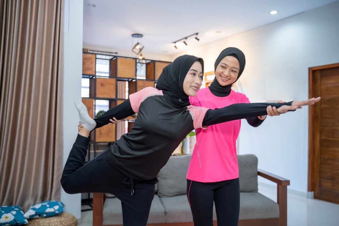 two-woman-hijab-exercising-helping-each-other-home (Medium)